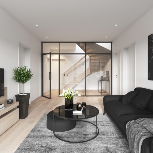 Modern living room with black sofa, round coffee table, TV on a wooden stand, potted plant, and abstract art. Glass wall reveals staircase and hallway in a bright, minimalist interior.