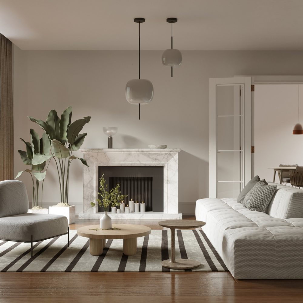 Modern living room with a white sectional sofa, striped rug, round wooden tables, potted plant, marble fireplace, and large windows; dining area with pendant lights visible in the background.